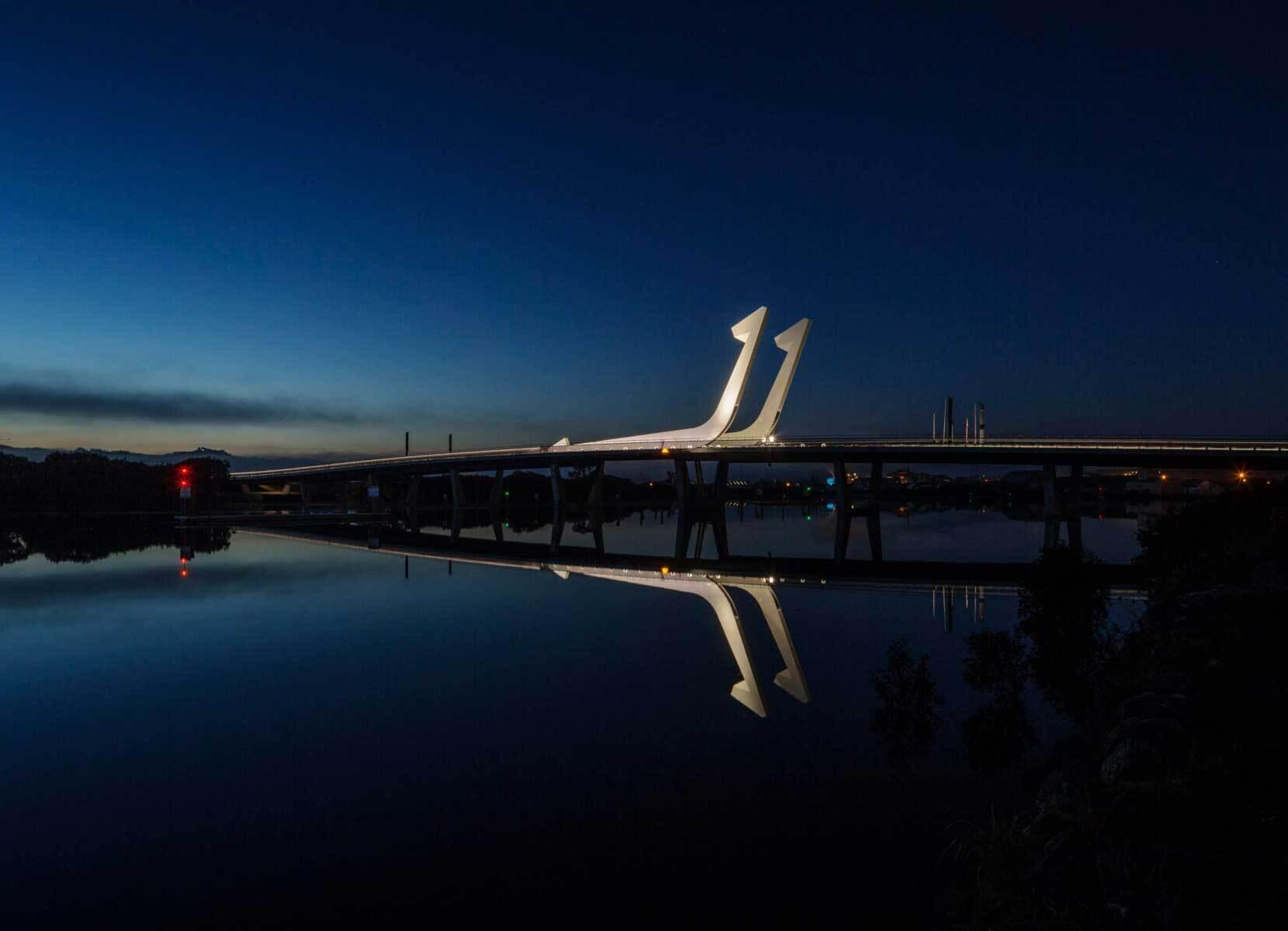 A bridge with a striking twin-fish-hook design over water
