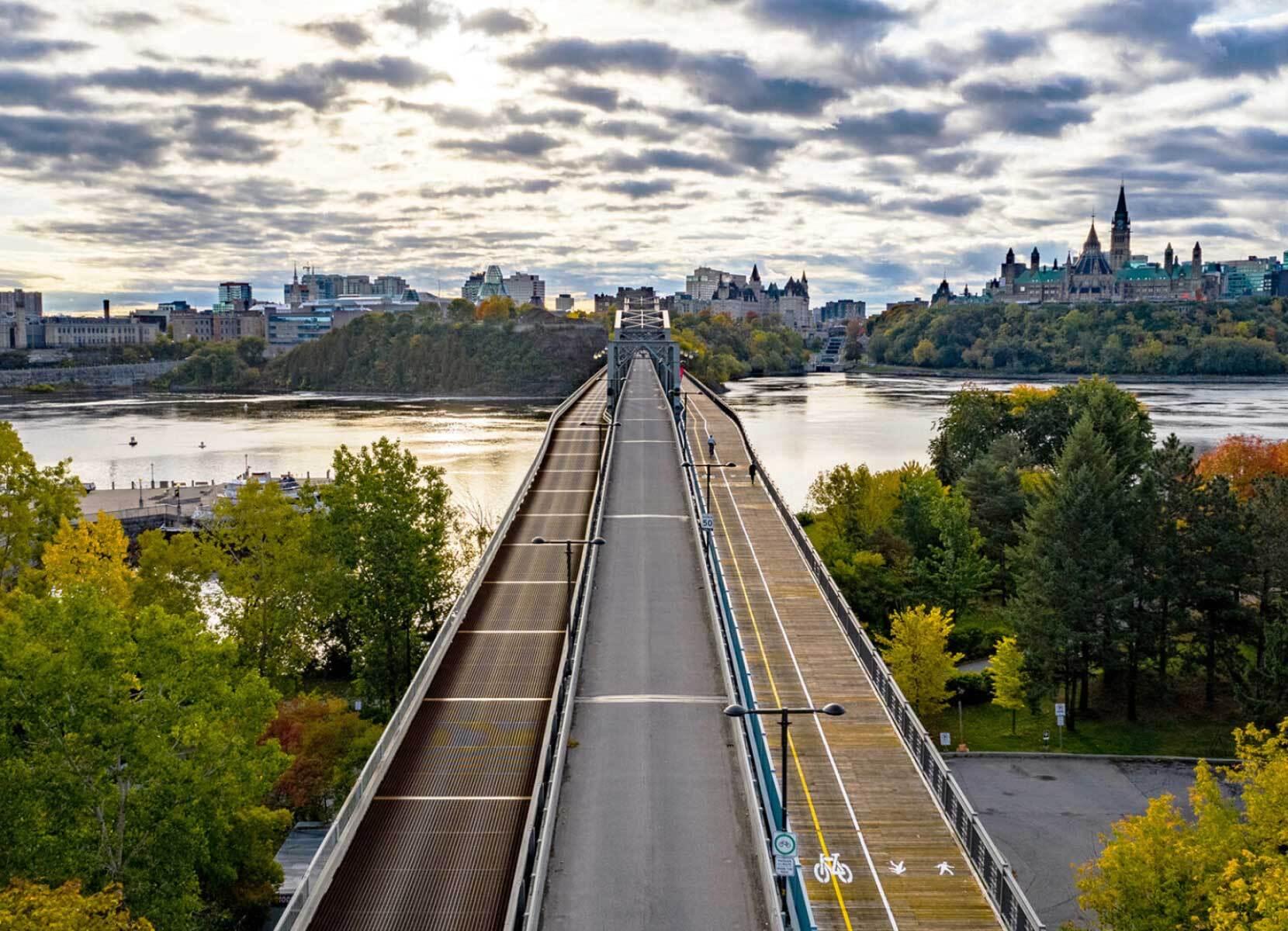 Vue d’une rive à l’autre d’un fleuve depuis un pont avec une séparation des voies cycles et piétonnes